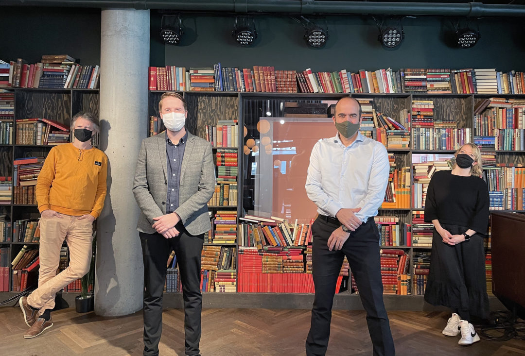 Erling, Ingemund, Lars Eirik og Maren står foran en bokhylle og ser mot kamera, alle med munnbind.